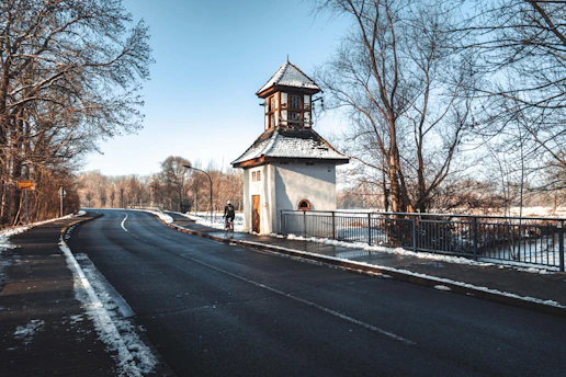 white and brown wooden house near bare trees under blue sky during daytime