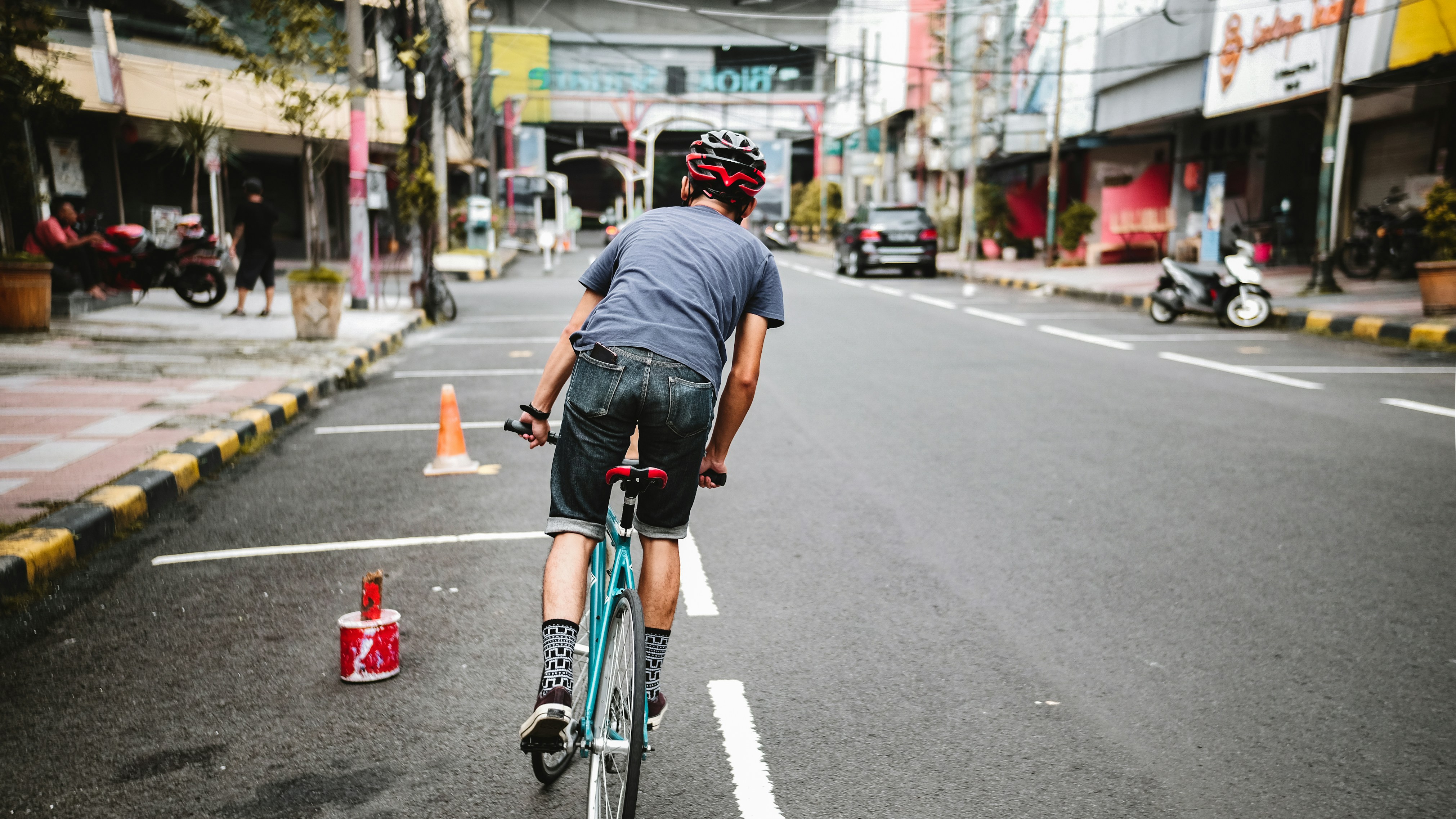 man in black t-shirt riding bicycle on road during daytime