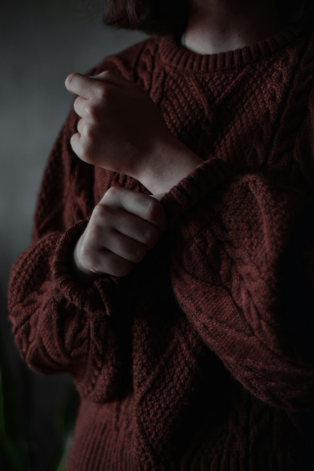 person holding red knit textile