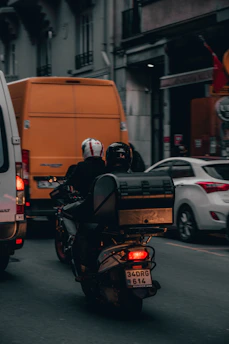 A motorcycle instructor guiding a beginner rider through urban traffic.