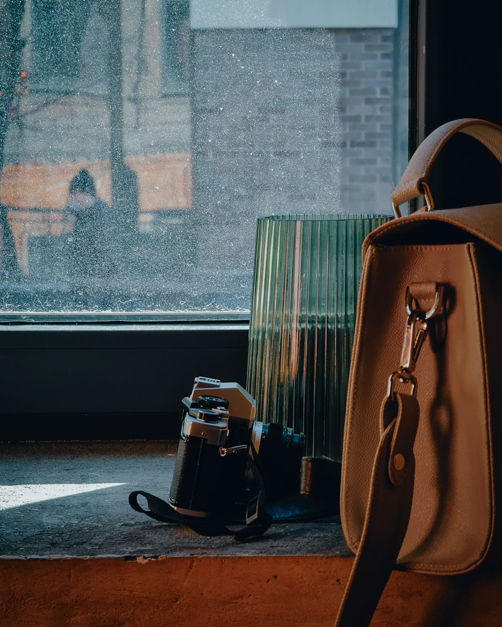 brown leather handbag beside black ceramic mug