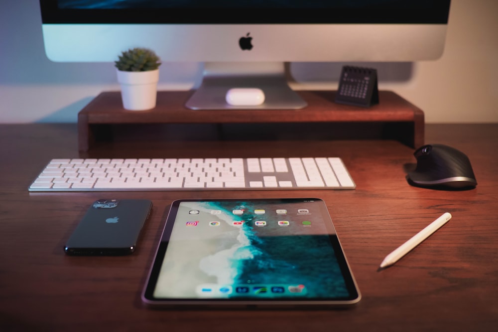 iMac plateado sobre mesa de madera marrón