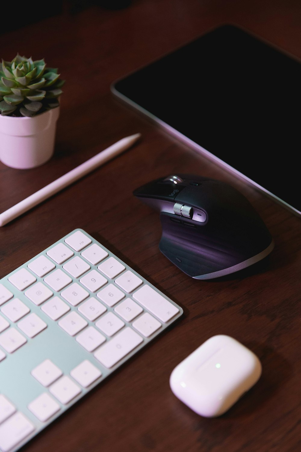 black and white cordless computer mouse beside apple keyboard