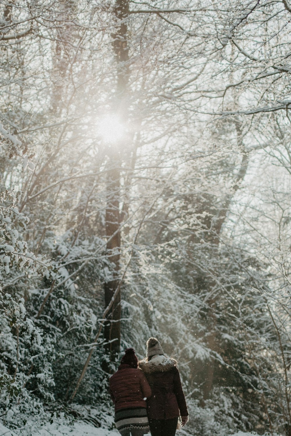 person in brown winter coat standing on snow covered ground during daytime