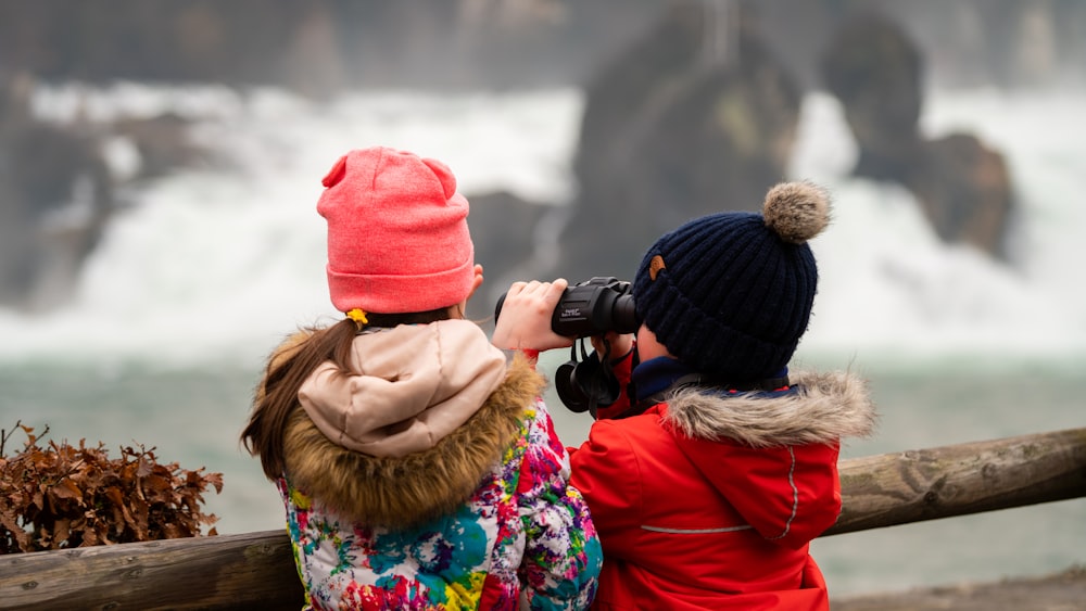 woman in red knit cap and brown jacket holding black dslr camera