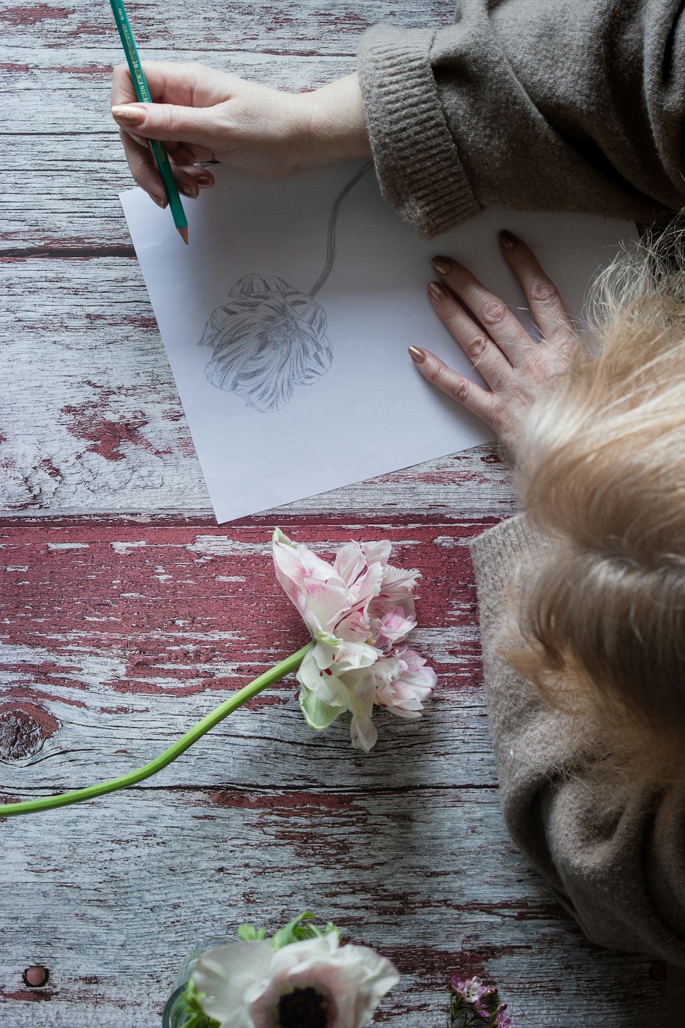 person holding white and pink floral card