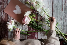 person holding white and pink flower bouquet