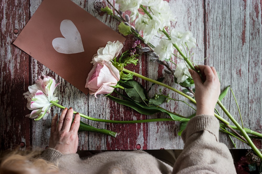 person holding white and pink flower bouquet