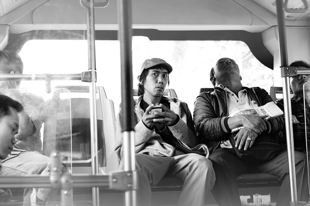 grayscale photo of man and woman sitting on train seat