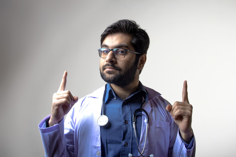 man in blue scrub shirt wearing black framed eyeglasses