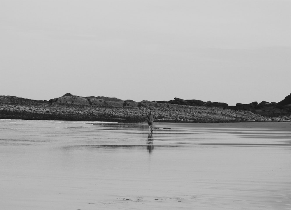 grayscale photo of person fishing on sea