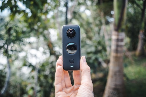 person holding black and gray camera