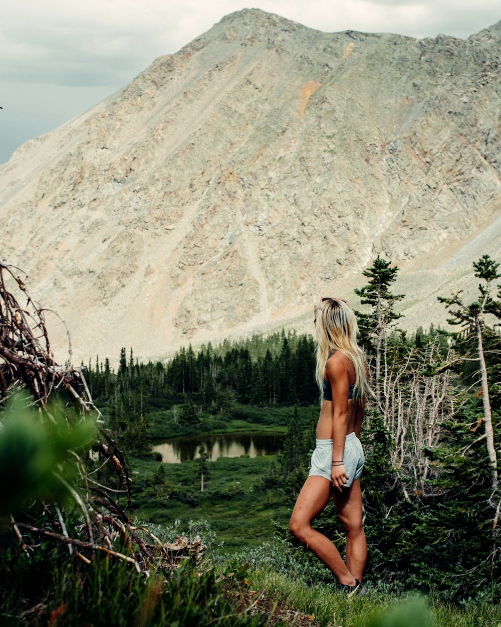 woman in white bikini standing on green grass field during daytime