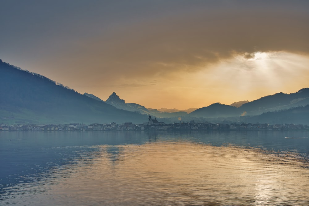 body of water near mountain during daytime