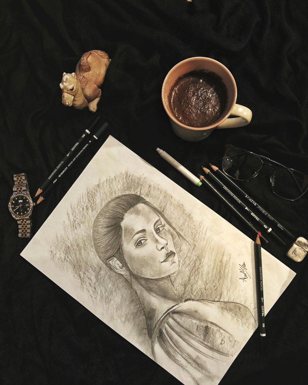 black and white man sketch beside brown ceramic mug