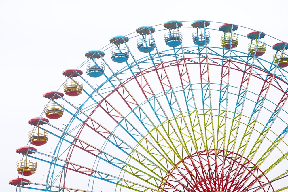 people riding on red and white ferris wheel during daytime