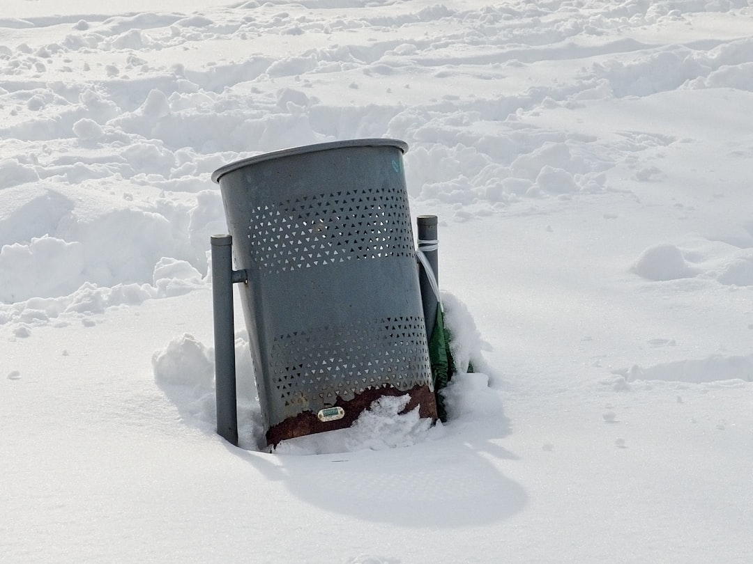black trash bin on snow covered ground