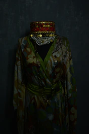 Elegant Moroccan clothing displayed on a mannequin against a dark cosmic gradient background.
