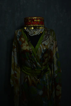 Elegant Moroccan clothing displayed on a mannequin against a dark cosmic gradient background.