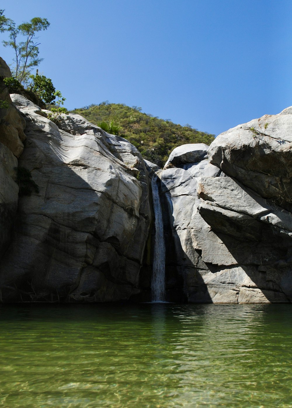 formazione rocciosa grigia accanto allo specchio d'acqua durante il giorno