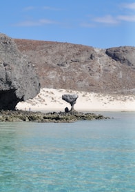 brown rock formation on blue sea water during daytime