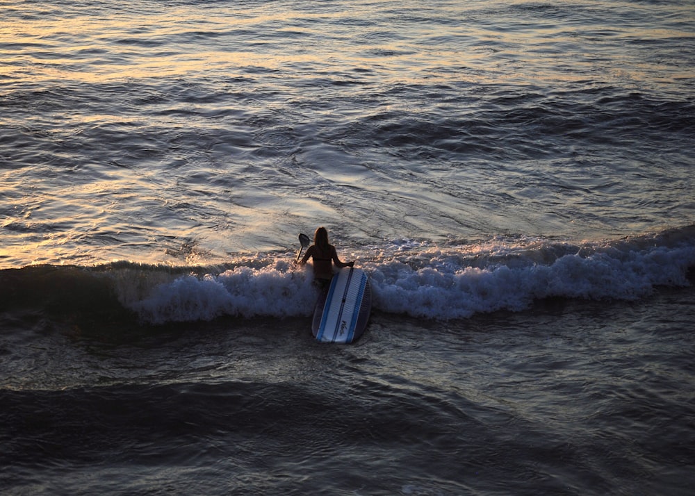 man surfing on sea waves during daytime