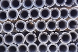 Steel pipes stacked neatly in a warehouse.