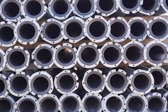 A large stack of metal pipes arranged in neatly aligned rows and columns.