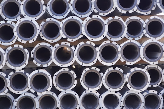 A large stack of metal pipes arranged in neatly aligned rows and columns.