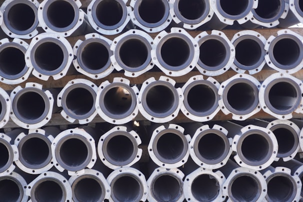 A large stack of metal pipes arranged in neatly aligned rows and columns.