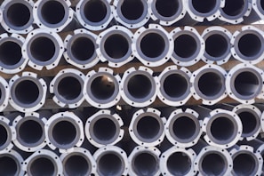 A large stack of metal pipes arranged in neatly aligned rows and columns.