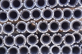 A large stack of metal pipes arranged in neatly aligned rows and columns.
