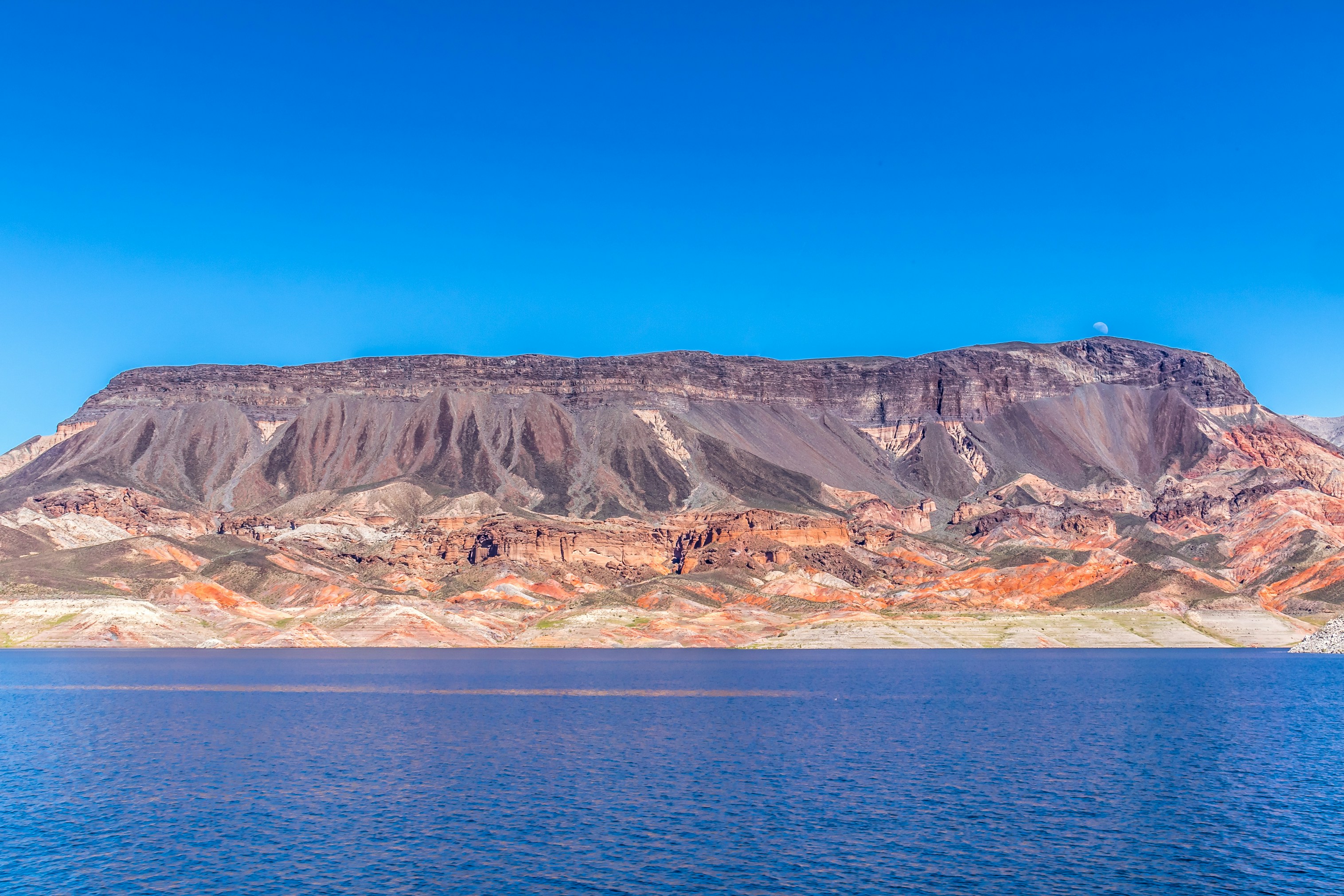 brown and white mountains near body of water during daytime
