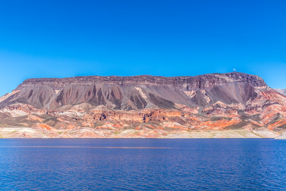 brown and white mountains near body of water during daytime