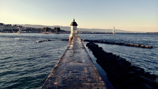 white lighthouse near body of water during daytime