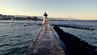 white lighthouse near body of water during daytime