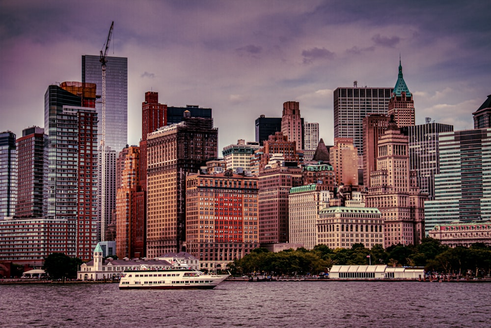 white and brown boat on water near city buildings during daytime