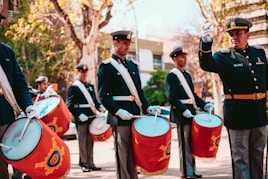 men in black and white uniform standing on street during daytime