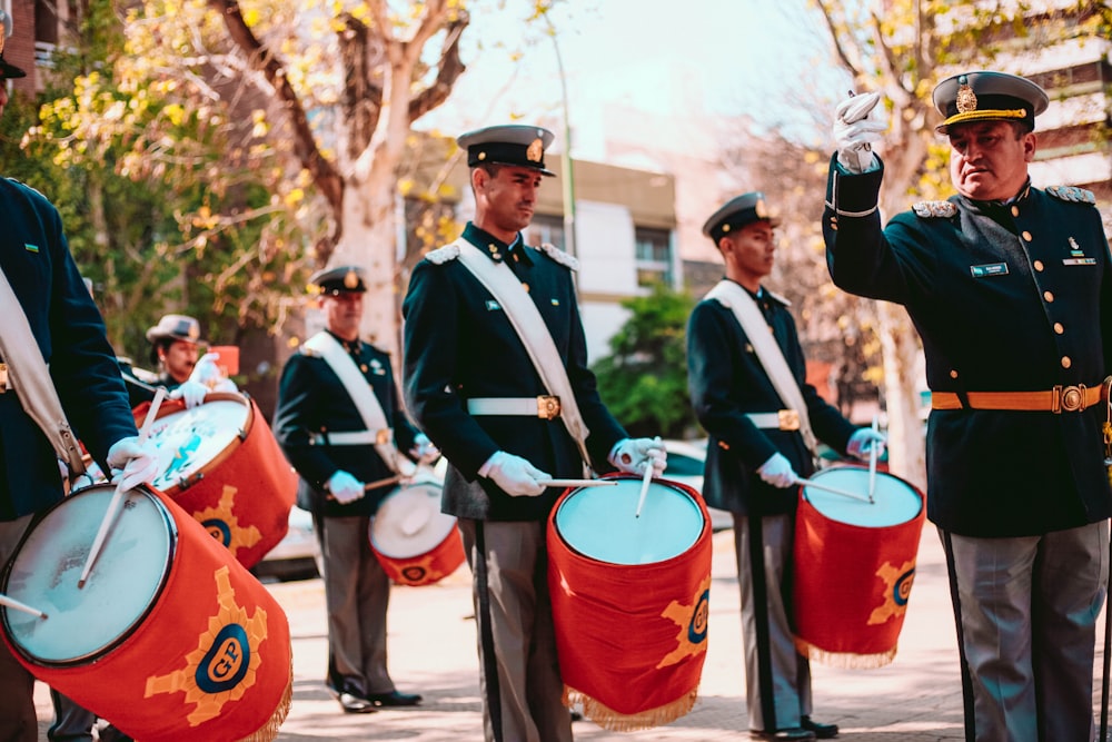 men in black and white uniform standing on street during daytime