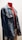 A denim jacket displayed on a mannequin, featuring embroidered patches and paired with a high-necked red shirt underneath. The setup is well-lit, highlighting the textures and colors of the jacket and shirt.