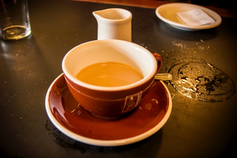 xícara de chá de cerâmica marrom no pires