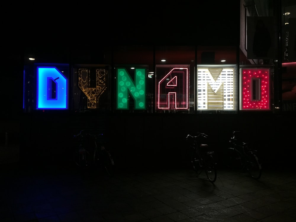 black bicycle parked near green and red led light signage