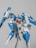 A highly detailed model of a futuristic blue and white robot with various angular components and weaponry. The robot has a sleek design with red, yellow, and gray accents, featuring large appendages that suggest advanced technology and flight capability.