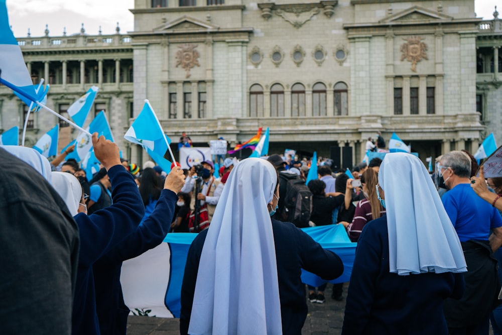 Foto Gente con túnica azul y blanca parada cerca de un edificio de hormigón  blanco durante el día – Imagen Guatemala gratis en Unsplash