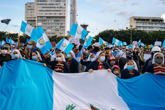 A group of teachers holding blue, white, and orange flags during a peaceful demonstration in Guadeloupe.