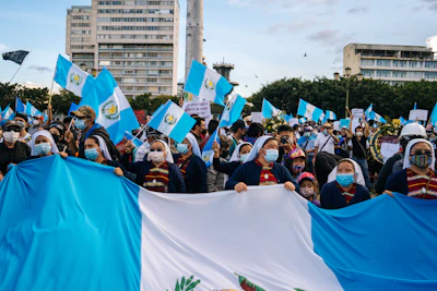 A group of teachers holding blue, white, and orange flags during a peaceful demonstration in Guadeloupe.