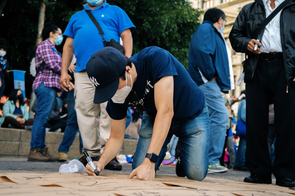 Mann in blauem T-Shirt und blauer Jeans hält Frau in schwarzem T-Shirt