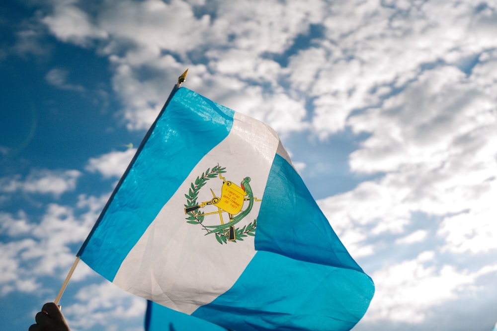 blau-weiße Flagge unter blau-weißem sonnigem Bewölkungshimmel tagsüber