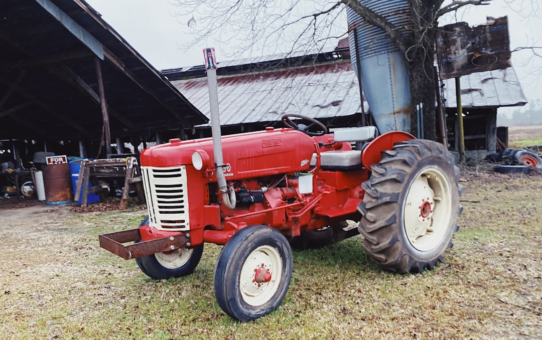 red tractor parked near white building
