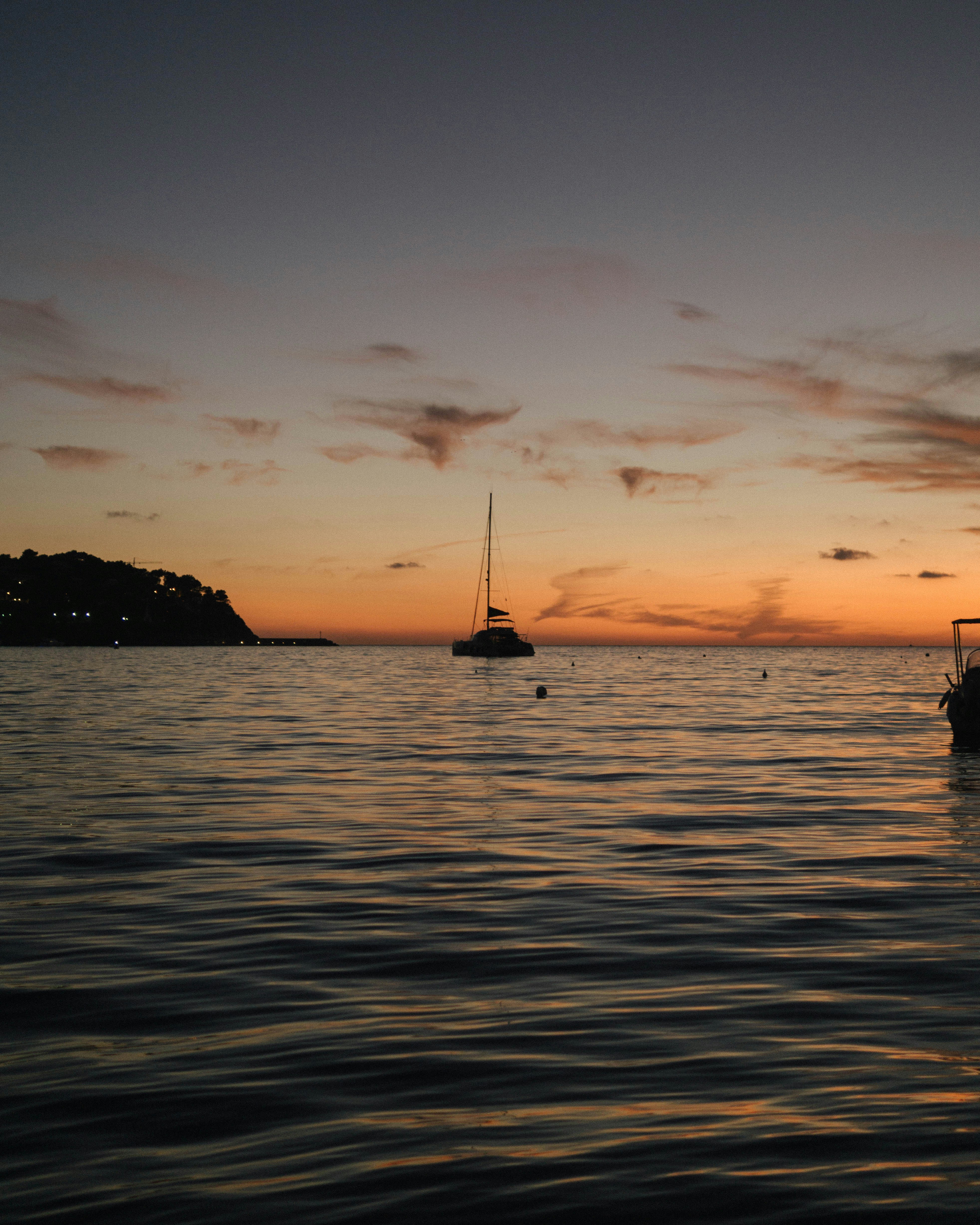 silhouette of boat on sea during sunset